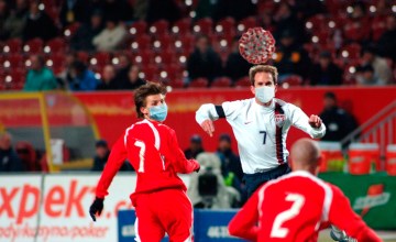 Futbolistas con mascarilla pelean por un balón en forma de coronavirus / FOTOMONAJE DE PdF