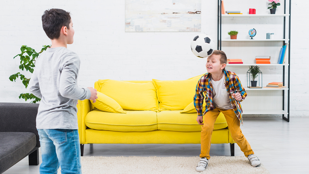 Dos niños juegan al fútbol en casa / FREEPIK