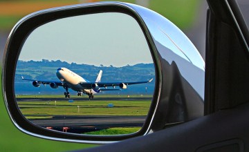 Un avión a punto de despegar visto desde el retrovisor de un coche / PIXABAY