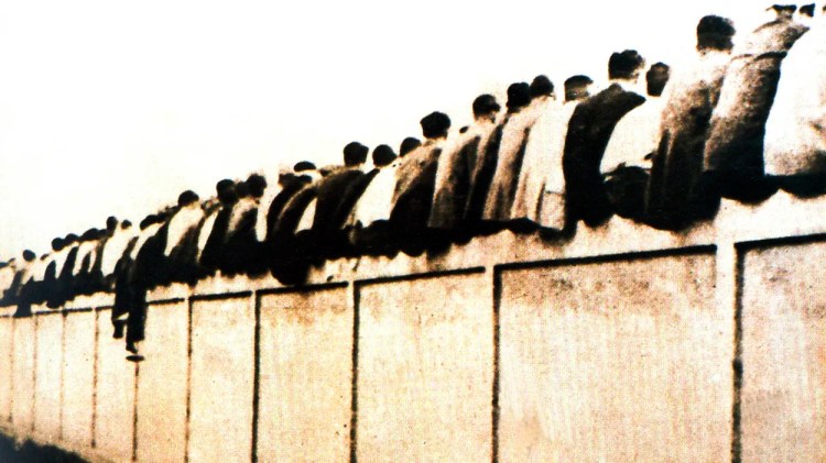 Aficionados del Barcelona sentados en el muro del campo de la calle Indústria, dejando sus culos a la vista, lo que dio origen a los culés / FCBARCELONA