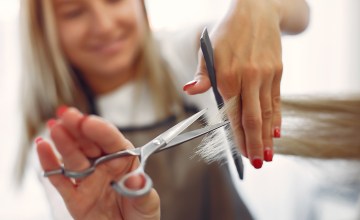 Una peluquera corta el pelo a una clienta en la peluquería / PROSTOOLEH
