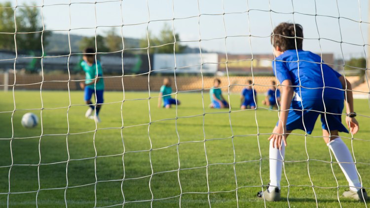 Un portero se prepara para detener el disparo del delantero rival / PEXELS