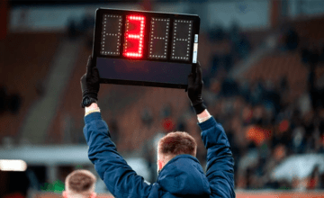 Un árbitro de fútbol muestra tres minutos de tiempo añadido, descuento, alargue o prolongación