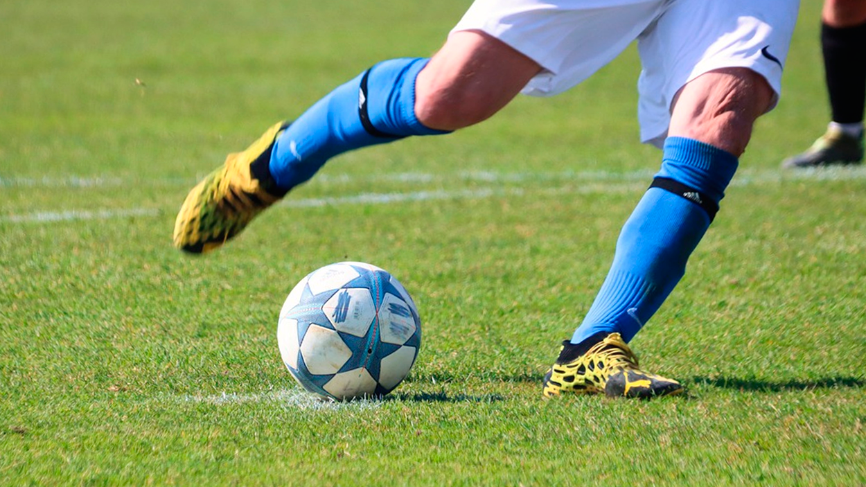 Un futbolista con botas de fútbol lanza un penalti