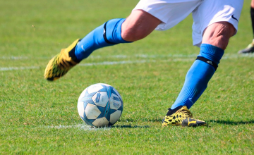 Un futbolista con botas de fútbol lanza un penalti